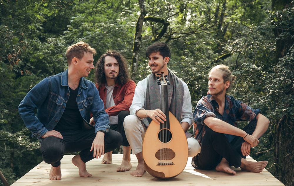 un groupe de 4 hommes avec une guitare au centre