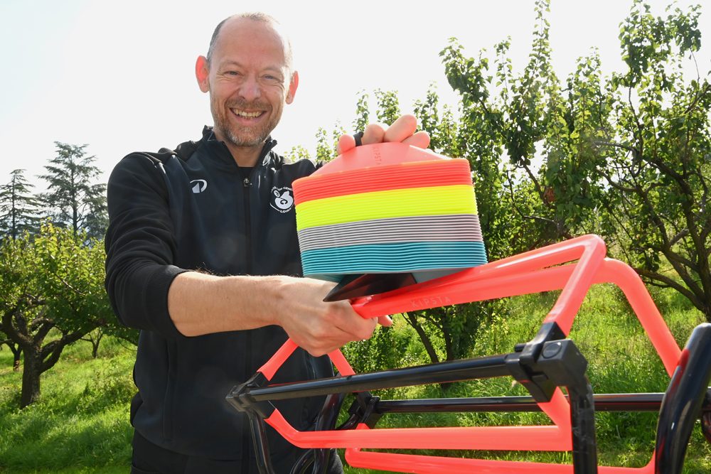 un homme souriant qui porte du matériel d'entrainement sportif