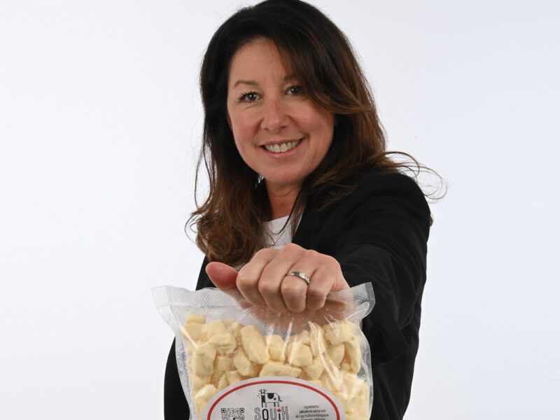 une femme souriante tenant un sac