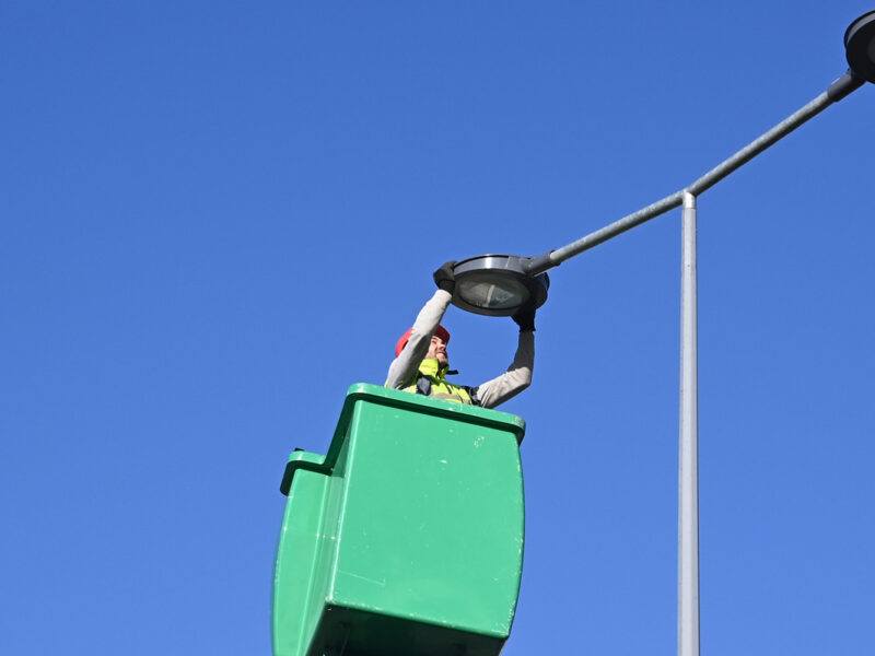 Une personne dans une nacelle qui remplace un éclairage public