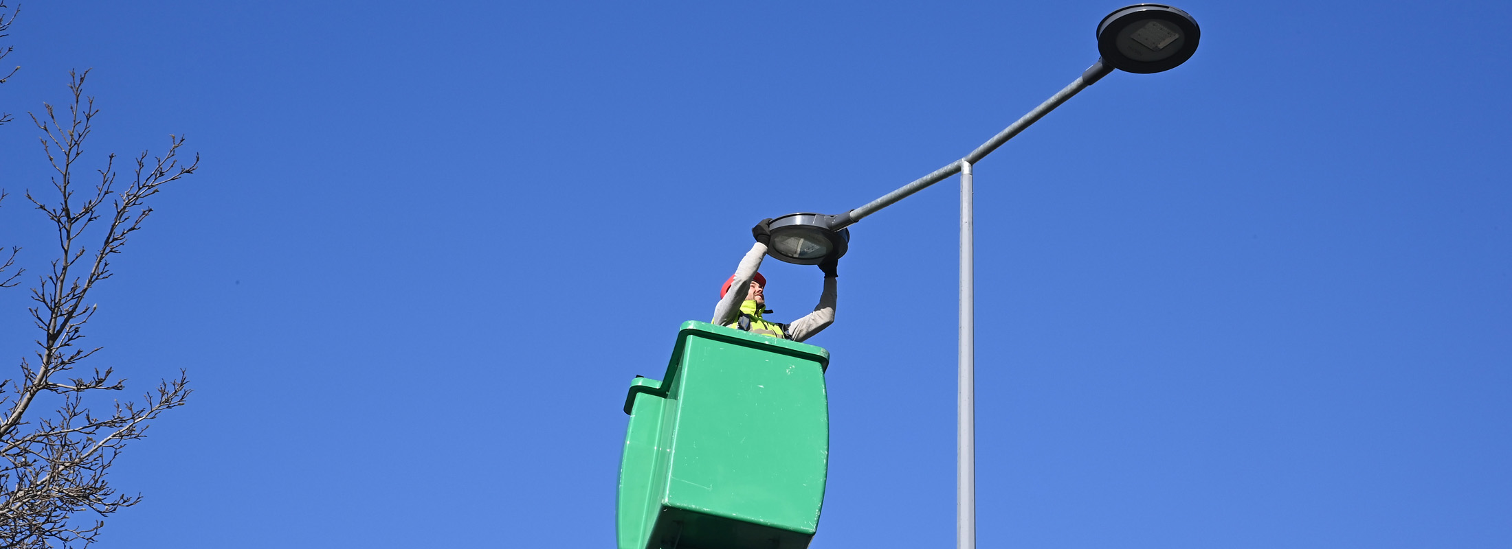 Une personne dans une nacelle qui remplace un éclairage public