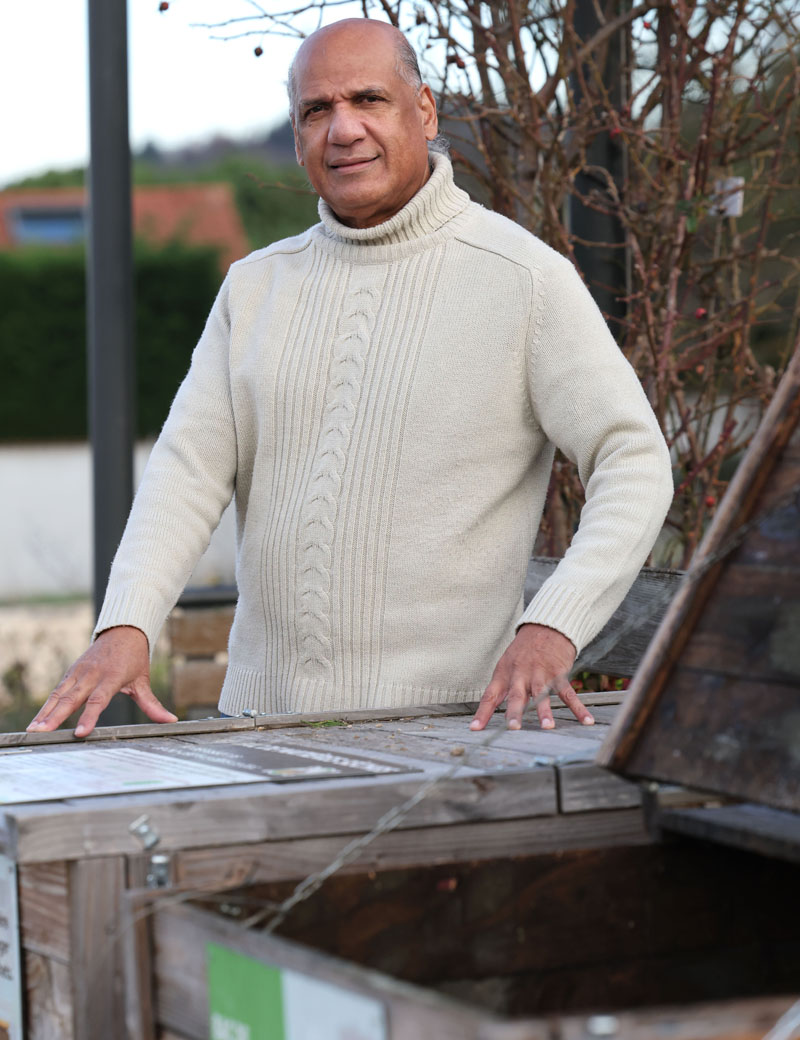 un homme devant des bacs de compostage