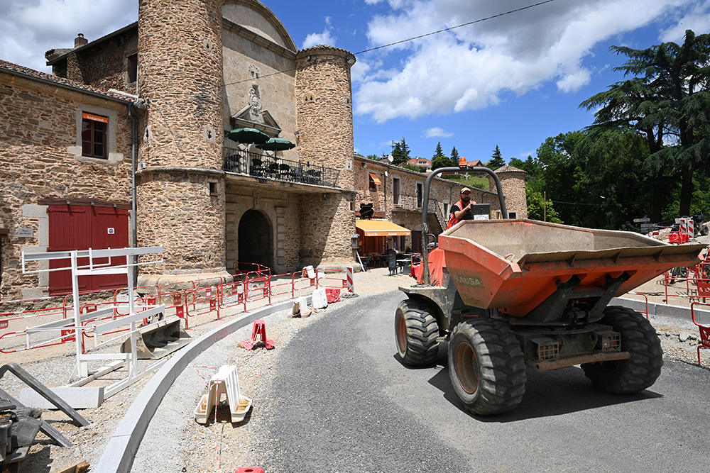 Travaux devant une très grande bâtisse en pierre