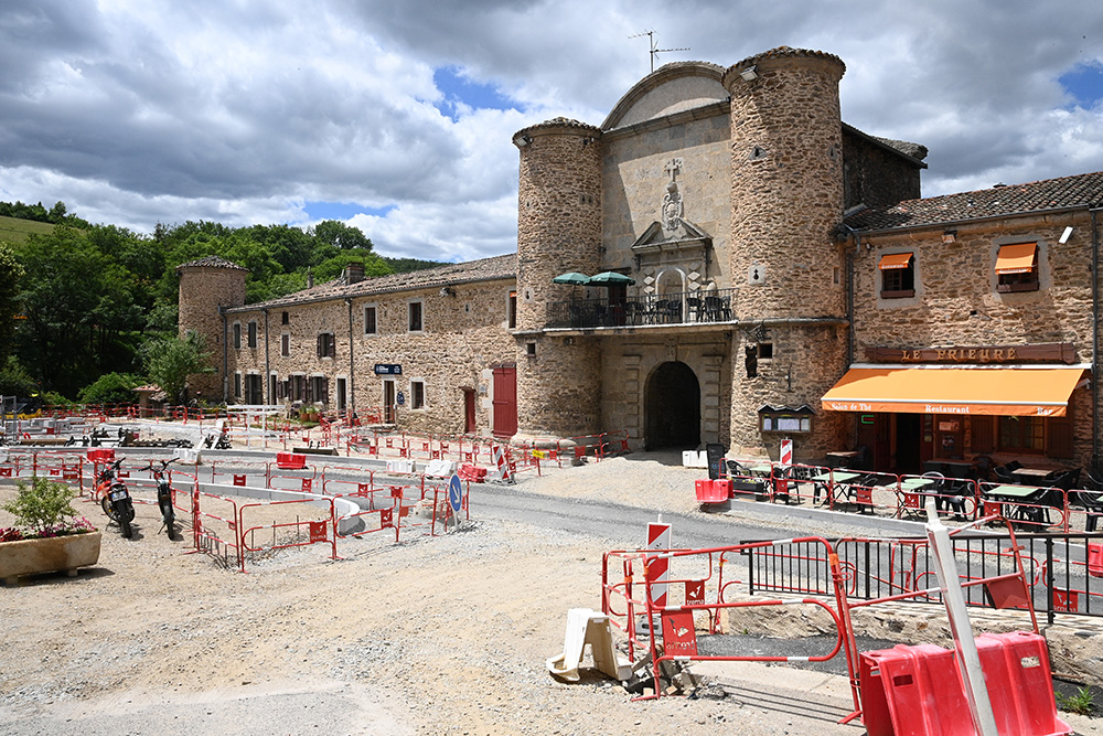 Travaux devant une très grande bâtisse en pierre