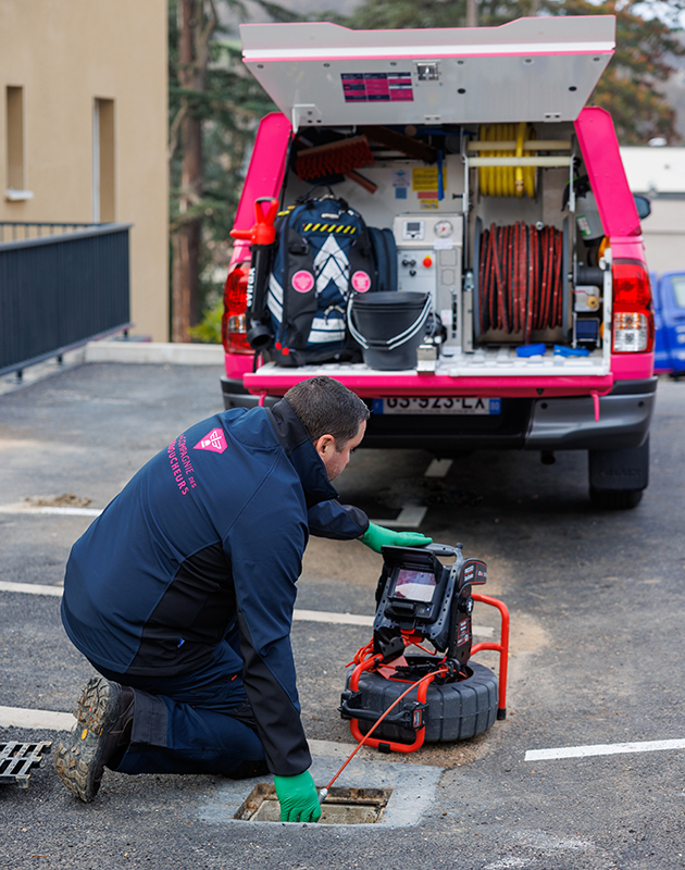 technicien et son véhicule qui inspecte des canalisations