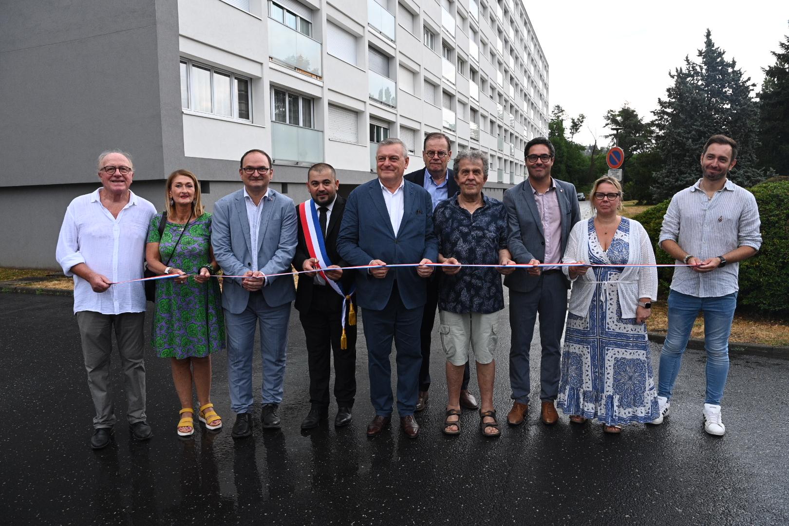 Groupe qui coupe un ruban devant un immeuble rénové
