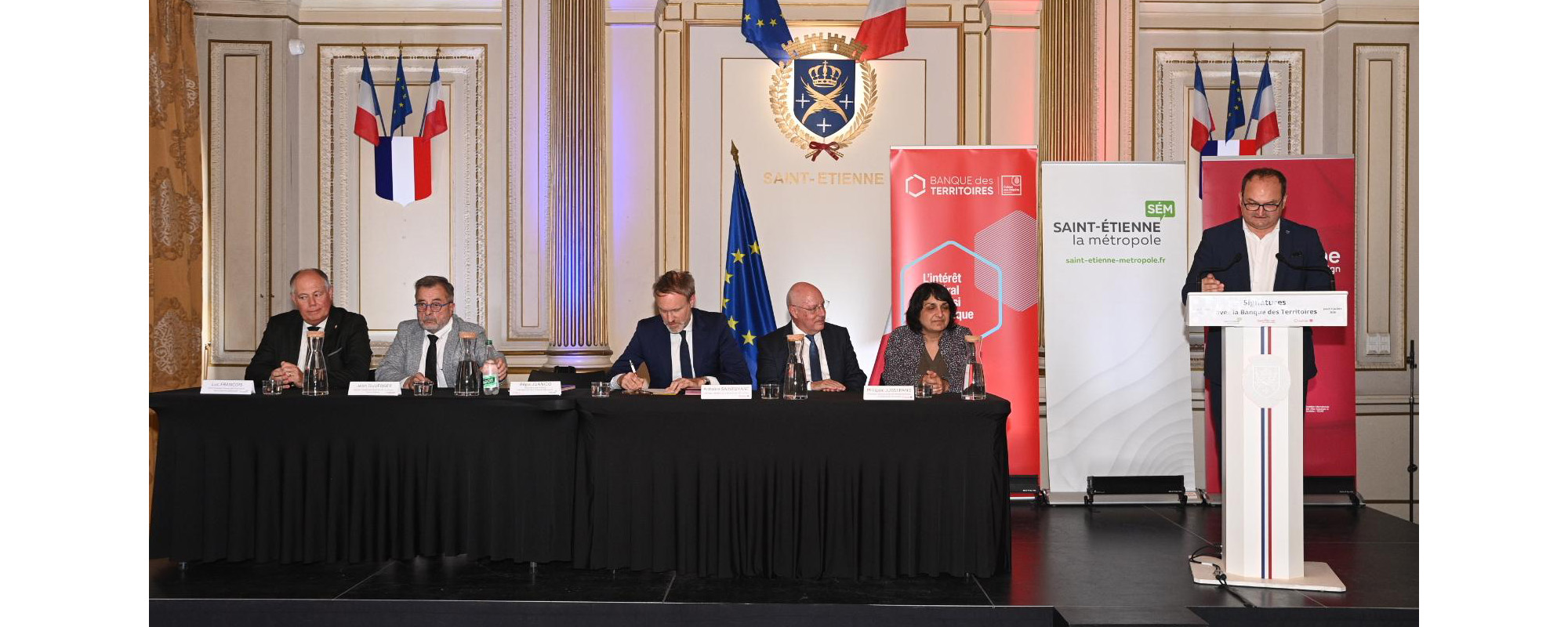 signature avec des élus assis et un autre au pupitre
